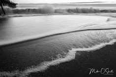 black and white photograph of waves crashing on the beach