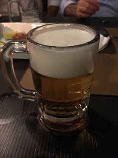 a glass of beer sitting on top of a table