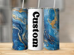 two blue and gold canisters sitting on top of a wooden table next to each other