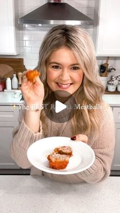 a woman holding a plate with some food on it