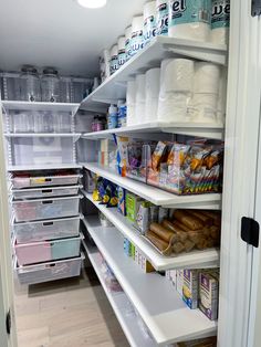 an organized pantry with white shelves and clear bins