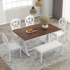 a dining room table with four chairs and a plate of food on the table in front of it