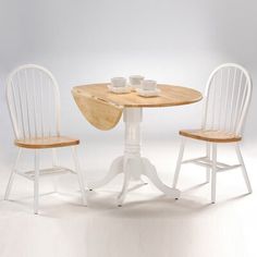 three chairs and a table with two cups on it in front of a white background