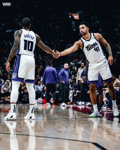 two basketball players shaking hands on the court