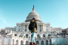 a woman standing in front of the capital building with her back to the camera, looking up