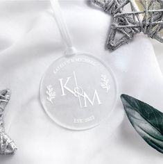 a glass ornament with the word mom engraved on it next to some christmas decorations