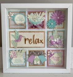 a white frame with some cards and flowers on the inside that says relax in gold lettering