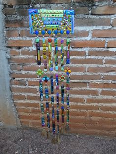 a multicolored wind chime hanging on a brick wall