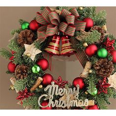 a christmas wreath hanging on the wall with decorations around it and merry lettering in front