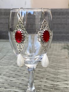 Gothic dangle earrings with tear drop pearls and red cabochon. Historical pearl drop earrings Materials used are Glass pearls, zinc alloy Centre cabochon is glass Measures as follows from top to bottom drop pearl 63mm including top pearl, excluding hooks Wrapped in gift box RETURNS EXCHANGES REFUNDS Returns, exchanges or refunds are accepted for may handmade jewellery pieces only from EU countries. Customer is responsible to pay for the return. Refund is for the cost of the product. For countrie Ornate Red Teardrop Jewelry, Nickel Free Elegant Red Chandelier Earrings, Elegant Nickel-free Red Chandelier Earrings, Red Elegant Nickel-free Teardrop Earrings, Victorian Teardrop Metal Jewelry, Red Cabochon Earrings For Wedding, Metal Chandelier Earrings With Pearl Drop As Gift, Ornate Pearl Drop Earrings For Gifts, Ornate Pearl Drop Chandelier Earrings As Gift