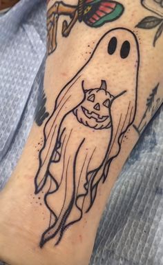 a person with a tattoo on their arm that has an image of a ghost in it