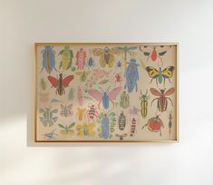 a painting hanging on the wall with bugs and insects painted on it's side