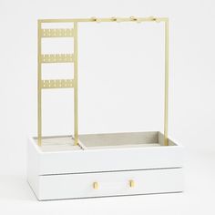 an open white box with a gold metal shelf and two drawers on the bottom side