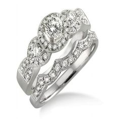 a wedding ring set with diamonds on the band and an oval shaped diamond in the center