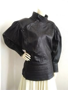 80s extravagant leather jacket, dolman sleeve, black leather jacket, very high waist jacket, batwing puffy sleeve jacket, quilted elasticated waist, asymmetric closure jacket high cuffs, no label size. The jacket is very beautiful, is not dry clean. have two small scratches, barely visible on the chest, and also another one on the back. Even the jacket have those very small sign of wear, the jacket is beautiful, extravagant and spectacular. measurements lying flat : shoulders and both sleeves together :173 cm (68 inches) bust :60 cm (23,5 inches) waist :41 cm (16 inches) high waist :20 cm (8 inches) total length :65 cm (25.5 inches) Myla Core, Waist Jacket, Archive Fashion, Satin Jackets, Sleeve Jacket, Leather Outfit, Black Leather Jacket, Historical Fashion, Dolman Sleeve