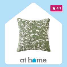 a green pillow sitting on top of a blue and white background with the words at home