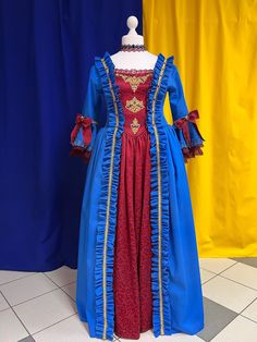 The dress is blue gabardin with a burgundy jacuard. The bustier is decoreted with a ruffle and golden ribbon. The closure in the back is burgundy lacing with grommets. The main decorative piece of the dress are the large ruffles, patterned on the edges of the top and the center bottom of the skirt. The sleeves are trimmed with openwork lace. In order to be able to fix the skirts in a desired position, the dress comes with soft crinoline. The look is completed with a lace neckband. We have this d Marie Antoinette Style Costume Dress With Ruffles, Marie Antoinette Gown For Costume Party, Marie Antoinette Style Fitted Fancy Dress, Fitted Overbust Fancy Dress, Marie Antoinette Style Gown For Costume Events, Ball Gown Dress With Ruffles For Costume, Fitted Overbust Costume Dress, Royal Style Fitted Fancy Dress, Royal Fitted Fancy Dress