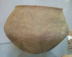 a large stone vase sitting on top of a glass table