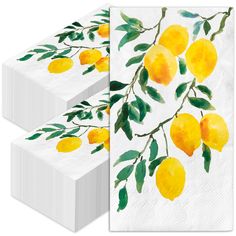 two white napkins with yellow lemons on them and green leaves painted on them