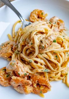 a white plate topped with pasta and shrimp