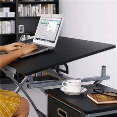 a woman sitting at a desk using a laptop computer