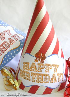 a red and white striped birthday hat sitting on top of a table next to other items