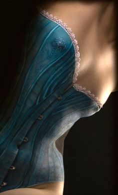 a mannequin wearing a blue dress with buttons on it's chest and back