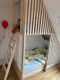 there is a bunk bed with a ladder to the bottom and a teddy bear on top