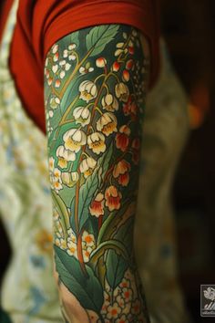 a woman's arm with flowers and leaves painted on the back of her body