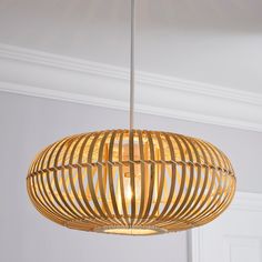 a wooden light fixture hanging from the ceiling in a room with white walls and trimmings