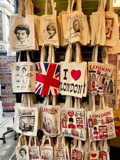 many bags are hanging up on the wall in front of a store window with pictures and words