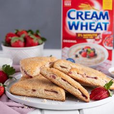 two strawberry shortcakes on a plate next to a carton of cream wheat