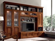 a living room with a large entertainment center and lots of glass doors on the wall