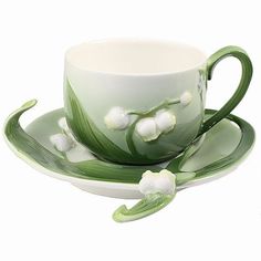 a cup and saucer decorated with white flowers