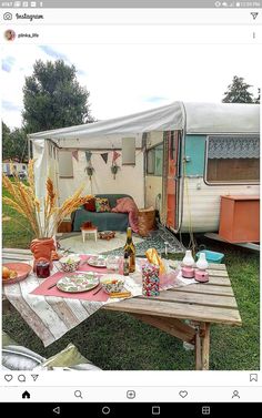 a table with food and drinks on it in front of a camper