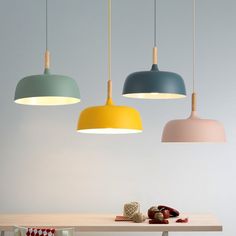 three different colored lamps hanging over a table