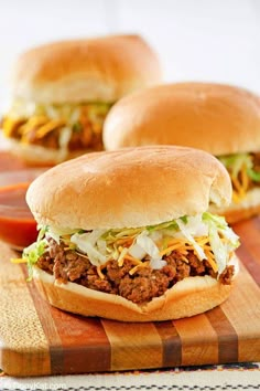 two sloppy joe sandwiches on a cutting board