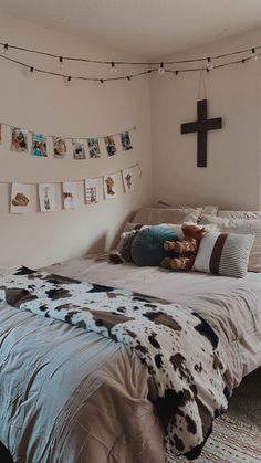 a bed room with a neatly made bed and a cross on the wall above it