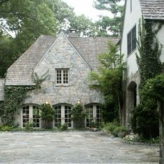 a large stone house with lots of windows and ivy growing on it's walls