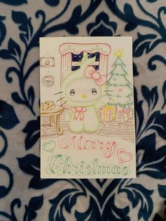 a christmas card with an image of a hello kitty sitting in front of a christmas tree