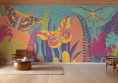 a colorful wall mural in a living room with chairs and rugs on the floor