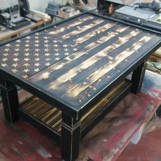 an american flag coffee table made out of pallet wood and ironing boards, sitting in a workshop