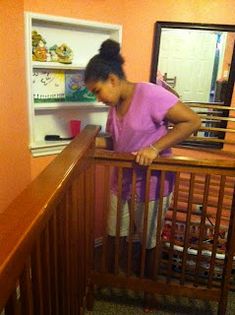 a woman standing at the top of a stair case in front of an open refrigerator