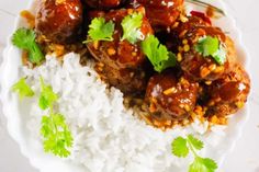 meatballs and rice with cilantro garnish on a white plate