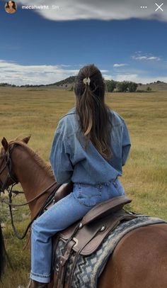 a woman riding on the back of a brown horse