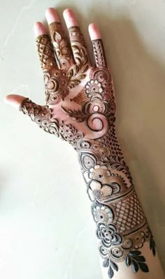 a woman's hand is decorated with henna and intricate designs on it,