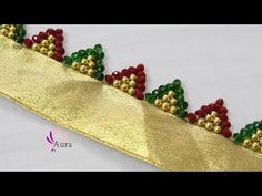 a gold ribbon with red and green beads on it