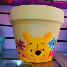 a flower pot with a cartoon bear painted on it