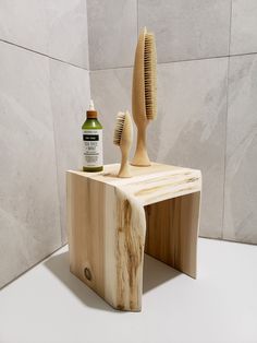 a wooden stand with a brush and comb on it next to a bottle of deodorant