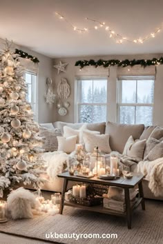 a living room decorated for christmas with white and silver decorations on the walls, a large tree